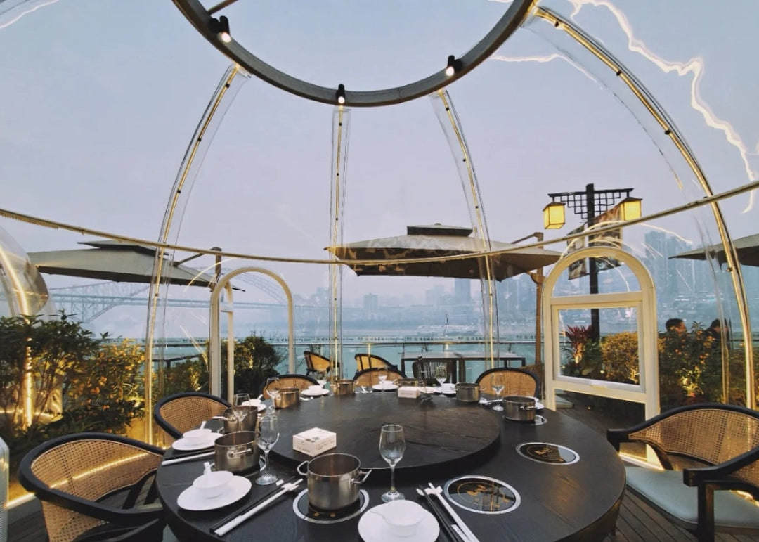 Dining table set with plates, cutlery, and glasses in a modern outdoor restaurant polycarbonate dome 